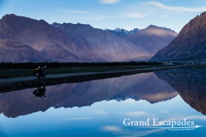 Mountains and motorbike reflecting in the water, Nubra Valley, Ladakh, India