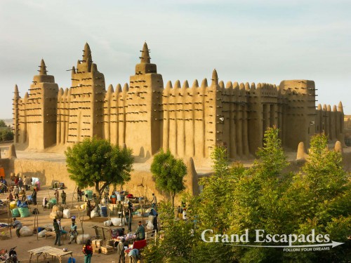 The biggest mud building in the world: the Mosque of Djenne at dawn on a market day, Mali